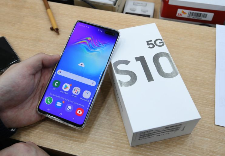 A customer checks his new Samsung Galaxy S10 5G smartphone during a launch event at an SK Telecom shop in Seoul on April 5, 2019. - The world's biggest smartphone and memory chip maker Samsung Electronics warned of a 60 percent-plus plunge in first-quarter operating profits on April 5, in the face of a weakening chip market. Samsung was also launching its top-end Galaxy S10 5G smartphone, after South Korea this week won the global race to commercially launch the world's first nationwide 5G networks. (Photo by JUNG Yeon-Je / AFP) (Photo credit should read JUNG YEON-JE/AFP/Getty Images)