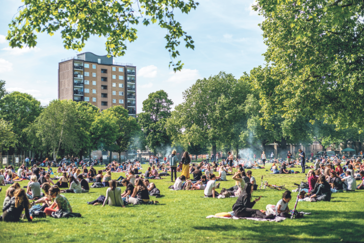 People relax on the grass in London Fields