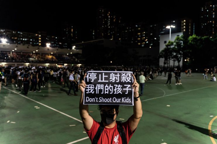 Hong Kong protester holds placard reading 'Don't shoot our kids'