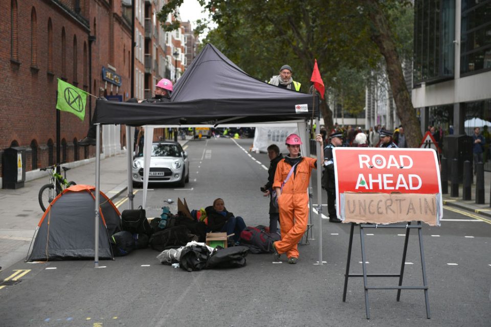 LONDON, ENGLAND - OCTOBER 07: Extinction Rebellion protesters block the road in Westminster on October 7, 2019 in London, England. Climate change activists are gathering to block access to various government departments as they start a two week protest in central London (Photo by Chris J Ratcliffe/Getty Images)