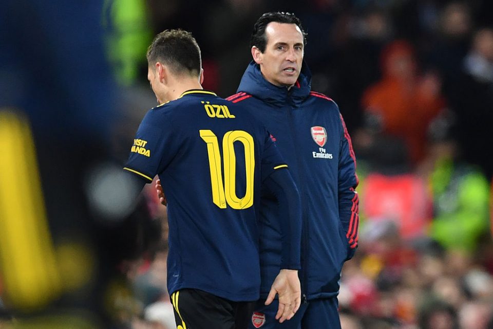 Arsenal's German midfielder Mesut Ozil (L) passes Arsenal's Spanish head coach Unai Emery as he leaves the pitch after being substituted off during the English League Cup fourth round football match between Liverpool and Arsenal at Anfield in Liverpool, north west England on October 30, 2019. (Photo by Paul ELLIS / AFP) / RESTRICTED TO EDITORIAL USE. No use with unauthorized audio, video, data, fixture lists, club/league logos or 'live' services. Online in-match use limited to 75 images, no video emulation. No use in betting, games or single club/league/player publications. / (Photo by PAUL ELLIS/AFP via Getty Images)