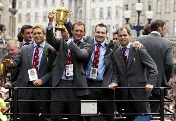 LONDON, UNITED KINGDOM: England's (front left-right) Jonny Wilkinson, Richard Hill, Mark Regan and Kyran Bracken ride the open-top bus with the Webb Ellis Cup during the Victory Parade in London, 08 December, 2003. Later the England Rugby World Cup winners were travelling to receptions at Buckingham Palace and Downing Street. AFP PHOTO/DAVID DAVIES/WPA POOL (Photo credit should read DAVID DAVIES/AFP/Getty Images)