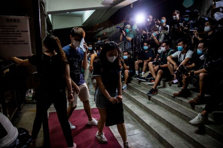 A women passes members of the mediaas she leaves a venue after voting in Hong Kong on June 20, 2020, during a vote organised by selection of pro-democracy unions to ask members if they will participate in a city wide strike and if they supported China's plans to impose a new national security law