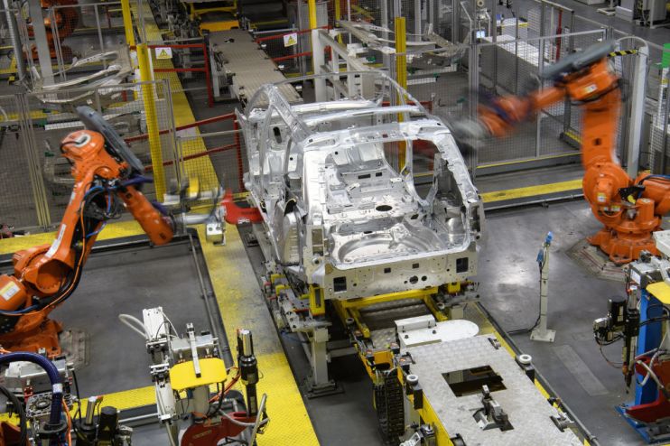 Robotic systems work on the chassis of a car during an automated stage of production at the Jaguar Land Rover factory in Solihull, England. (Photo by Leon Neal/Getty Images)