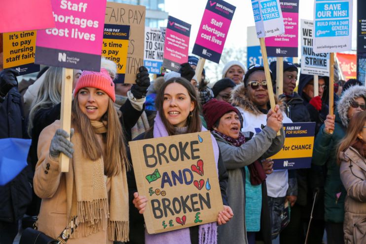 NHS nurses hold placards expressing their opinion during a