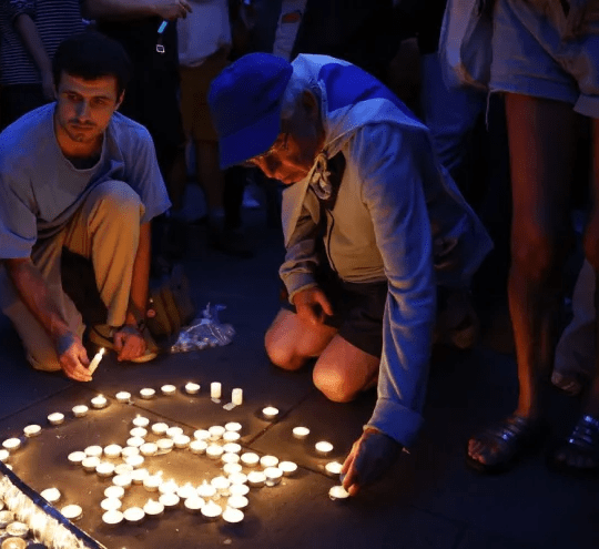 Members of the Jewish community light candles during a vigil for Israel at Downing Street.