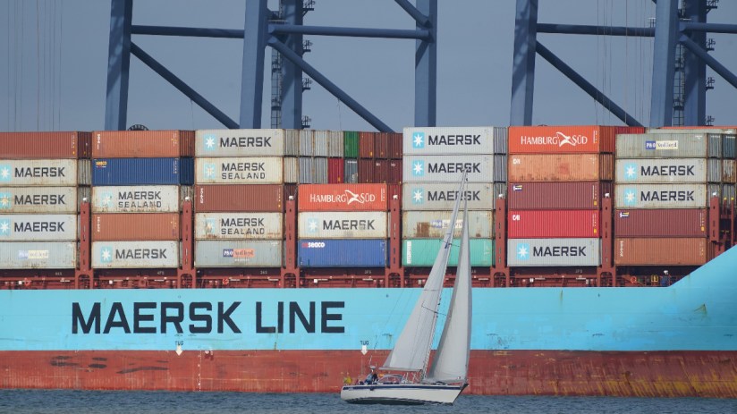 A yacht sailing past the container ship Vuoksi Maersk being loaded at the Port of Felixstowe, in Felixstowe, Suffolk, seen from Harwich, Essex. (Yui Mok/PA Wire)