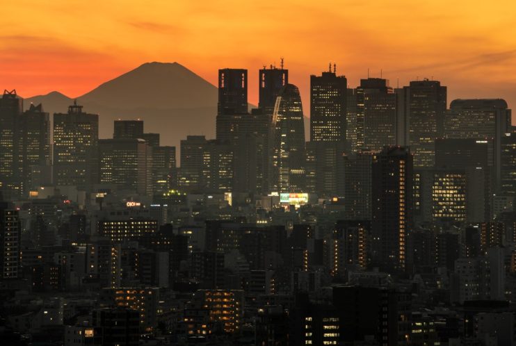 TOKYO, JAPAN - DECEMBER 23: Mount Fuji is seen behind the city skyline at dusk on December 23, 2020 in Tokyo, Japan. (Photo by Carl Court/Getty Images)