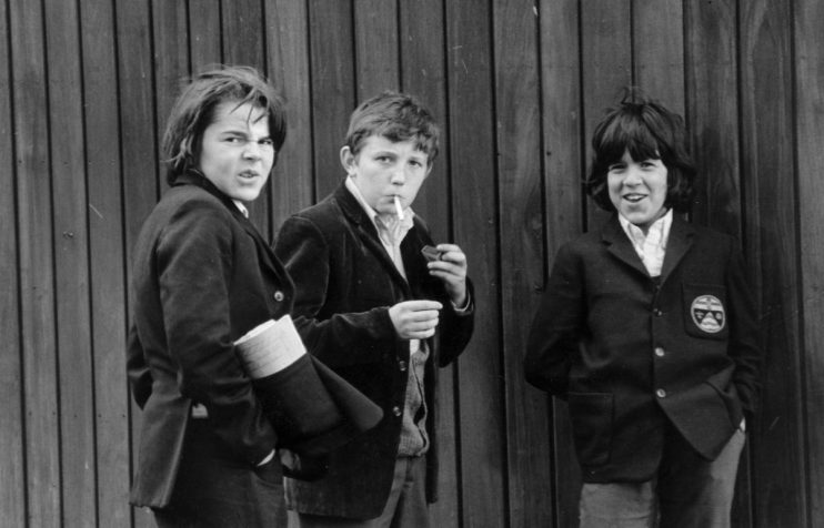 May 1972: Three secondary schoolboys smoking an illicit cigarette in Hyde Park, London. (Photo by Evening Standard/Getty Images)