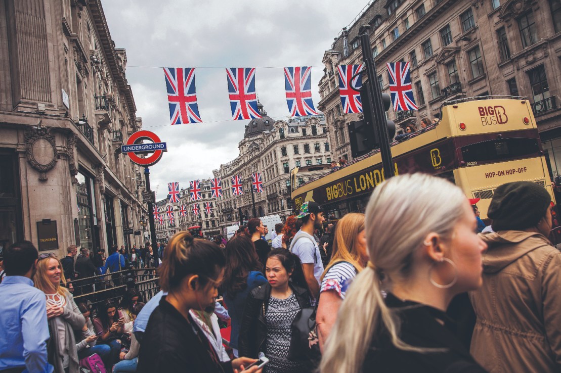 Pedestrians crossed the road at a crossing on Oxford Circus as British Union flags hang above Regent Street in London, U.K., on Tuesday, May 24, 2016. U.K. retail sales began the second quarter with more momentum than economists forecast. Photographer: Simon Dawson/Bloomberg via Getty Images