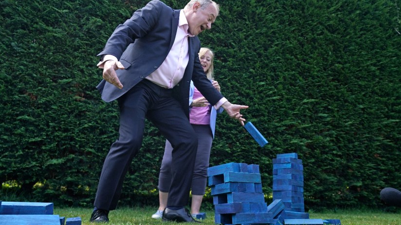 Lib Dem leader Sir Ed Davey plays Jenga with blue blocks representing the Conservative Party's seats. Photo: PA