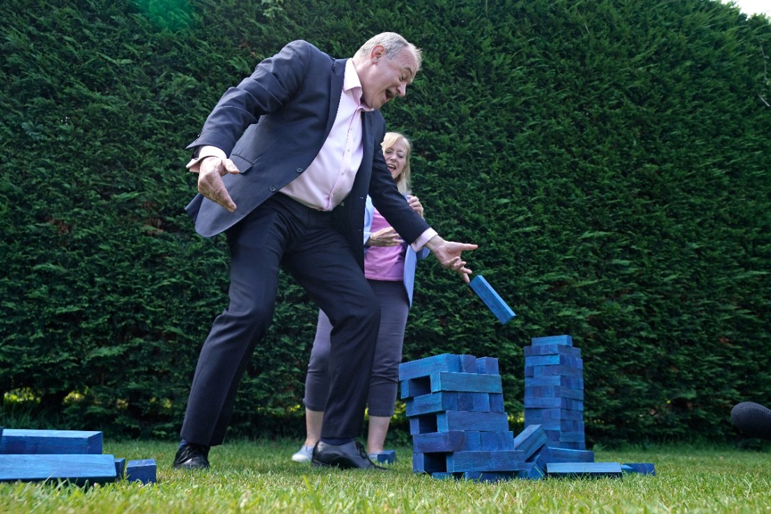 Lib Dem leader Sir Ed Davey plays Jenga with blue blocks representing the Conservative Party's seats. Photo: PA