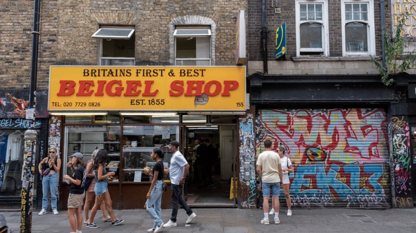 Street scene with customers and local people hanging outside the Beigel Shop on Brick Lane. (photo by Mike Kemp/In Pictures via Getty Images)