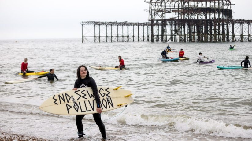 Surfers take part in a protest against water firms' pollution track record