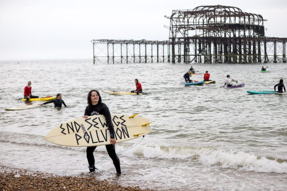 Surfers take part in a protest against water firms' pollution track record