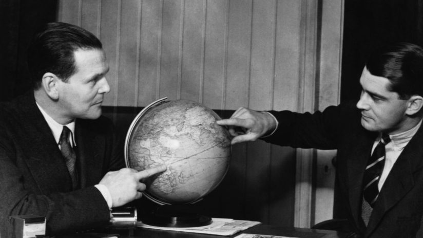circa 1958: Two men discuss business development with the aid of a globe. (Photo by General Photographic Agency/Getty Images)