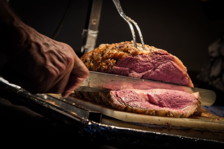 A person cutting a joint of beef