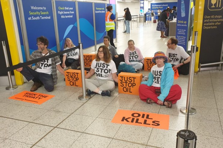 Just Stop Oil activists block a departure gate at Gatwick. Credit: Just stop Oil