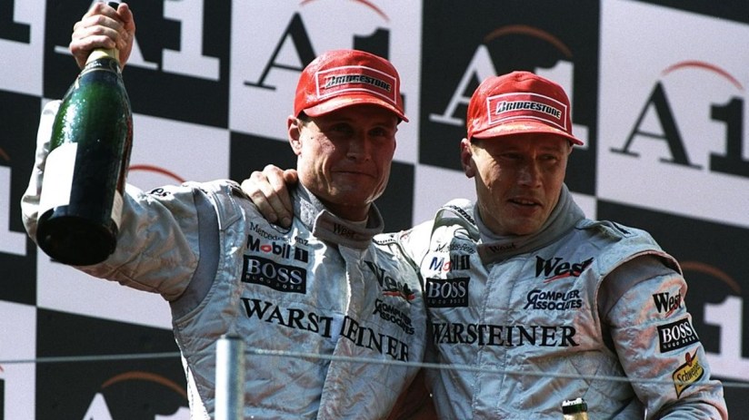 McLaren-Mercedes drivers David Coulthard (left) of Great Britain and Mika Hakkinen of Finland celebrate with champagne after the Austrian Grand Prix at the A1 Ring in Spielberg, Austria. Hakkinen finished in first place and Coulthard in second. Credit: Mike Cooper/Allsport