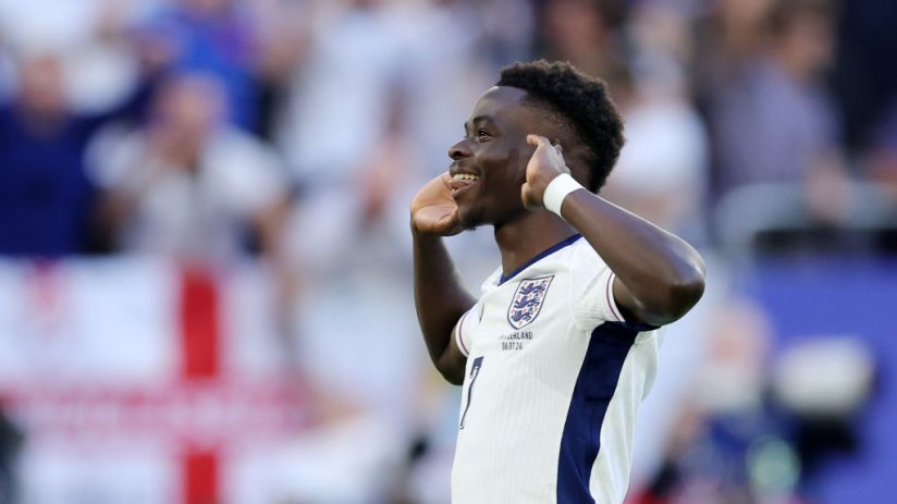 Bukayo Saka cups his ears in celebration