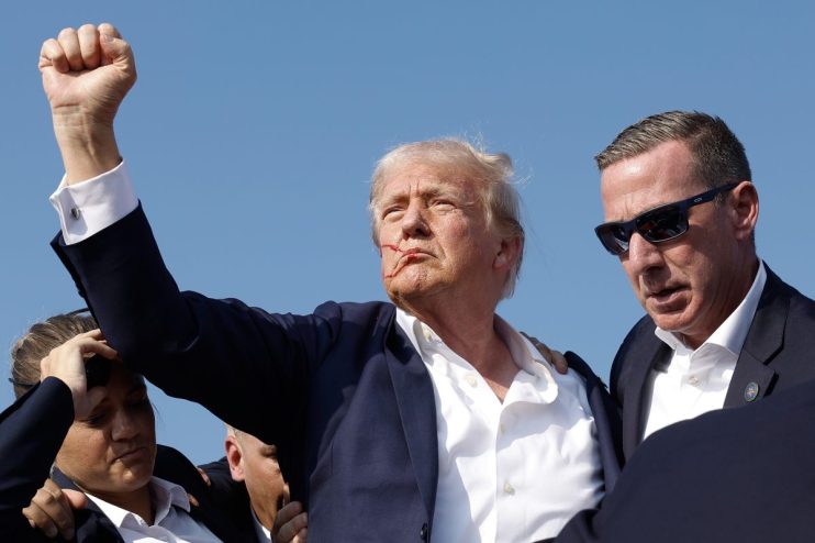 BUTLER, PENNSYLVANIA - JULY 13: Republican presidential candidate former President Donald Trump pumps his fist as he is rushed offstage during a rally on July 13, 2024 in Butler, Pennsylvania. Butler County district attorney Richard Goldinger said the shooter is dead after injuring former U.S. President Donald Trump, killing one audience member and injuring another in the shooting. (Photo by Anna Moneymaker/Getty Images)