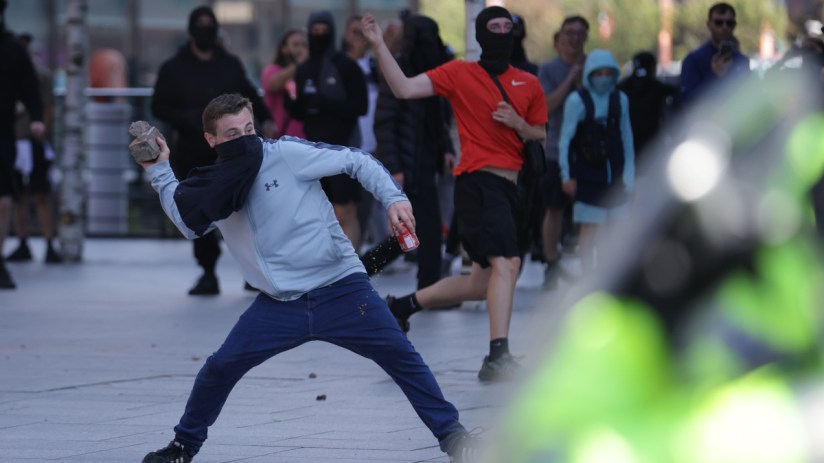 A man throws a brick during a protest in Liverpool, following the stabbing attacks on Monday in Southport, in which three young children were killed. Photo: PA