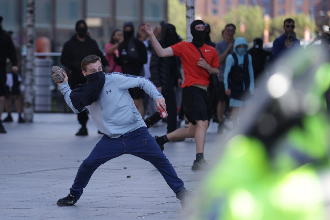 A man throws a brick during a protest in Liverpool, following the stabbing attacks on Monday in Southport, in which three young children were killed. Photo: PA