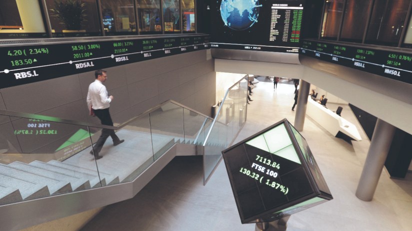 The FTSE 100 reshuffle will likely see Tritax Big Box and Hiscox moving to the main market. (Electronic ticker tape showing the FTSE 100 inside the London Stock Exchange. (Photo credit should read: Nicholas .T. Ansell/PA Wire))