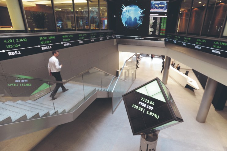 The FTSE 100 reshuffle will likely see Tritax Big Box and Hiscox moving to the main market. (Electronic ticker tape showing the FTSE 100 inside the London Stock Exchange. (Photo credit should read: Nicholas .T. Ansell/PA Wire))
