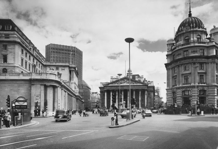 The Bank of England (left) and the London Stock Exchange (behind), with the neoclassical Royal Exchange building (centre), and the offices of the Royal Insurance Group (right), on Bank Junction in the City of London, England, June 1974. Bank London Underground station is visible in the lower lefthand corner of the frame. (Photo by Phillips/Fox Photos/Hulton Archive/Getty Images)