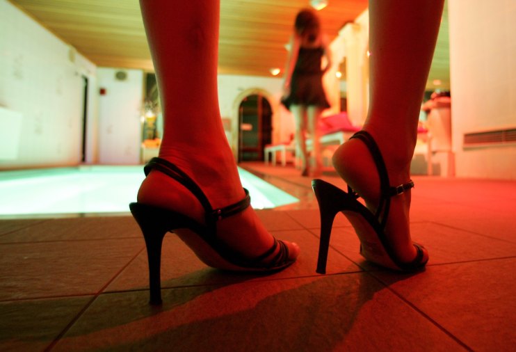 A pair of high-heeled shoes in a dimly lit room