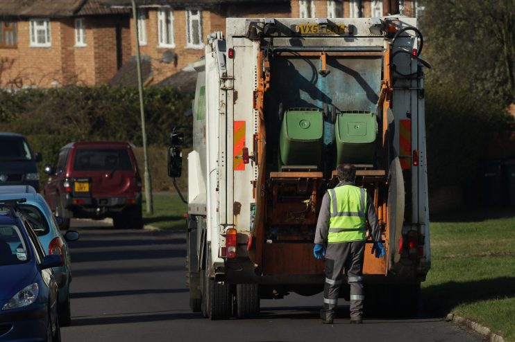 LEATHERHEAD, UNITED KINGDOM - MARCH 02: Refuse collectors empty green 'wheelie' bins on March 2, 2010 near Leatherhead, England. As the UK gears up for one of the most hotly contested general elections in recent history it is expected that the economy, immigration, the NHS and education are likely to form the basis of many of the debates. (Photo by Peter Macdiarmid/Getty Images)