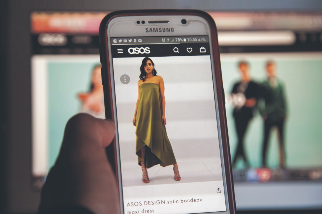 In this photo illustration, a woman is seen shopping on ASOS the online fashion store on a mobile phone. (Photo Illustration by Dinendra Haria/SOPA Images/LightRocket via Getty Images)