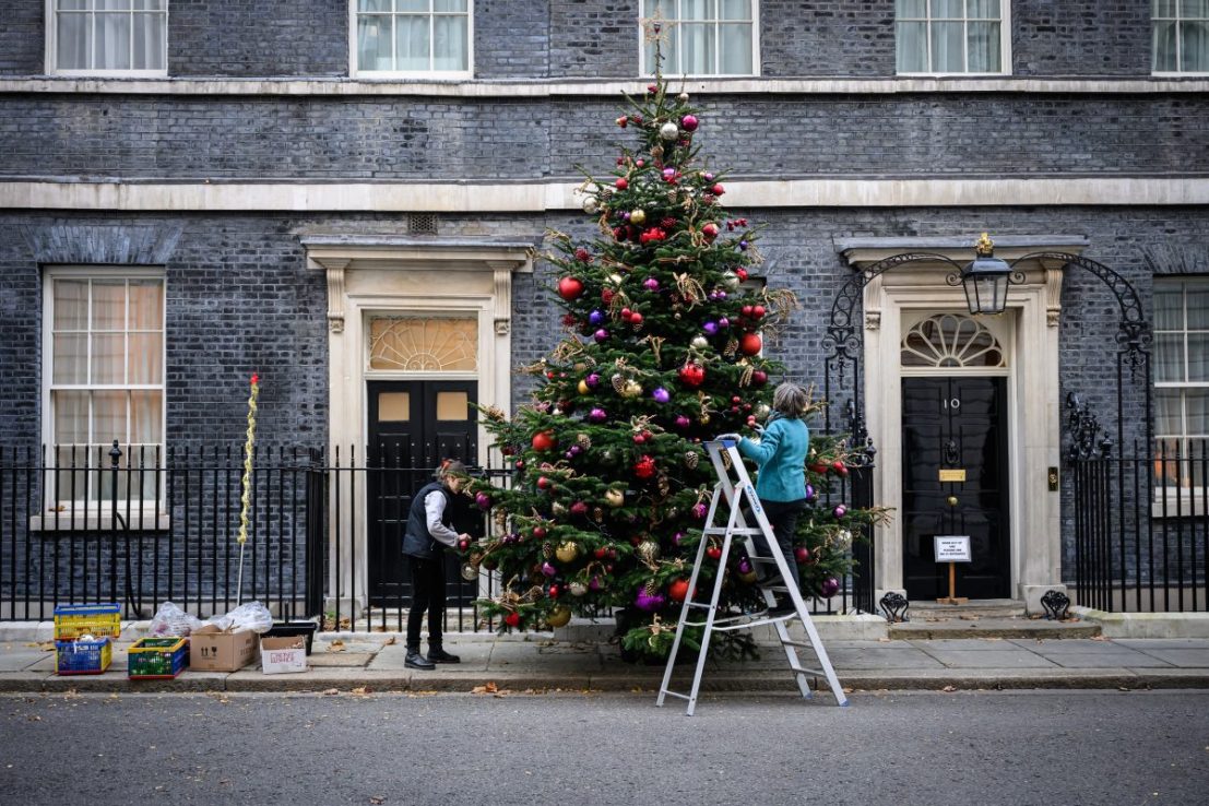 LONDON, ENGLAND - NOVEMBER 29: Two women hang baubles and decorations on the Downing Street Christmas tree as it is dressed ahead of the official unveiling next week, at Downing Street on November 29, 2024 in London, England. No. 10 Downing Street, the official residence and office of the British Prime Minister, has erected a Christmas tree in preparation for the festive season. (Photo by Leon Neal/Getty Images)