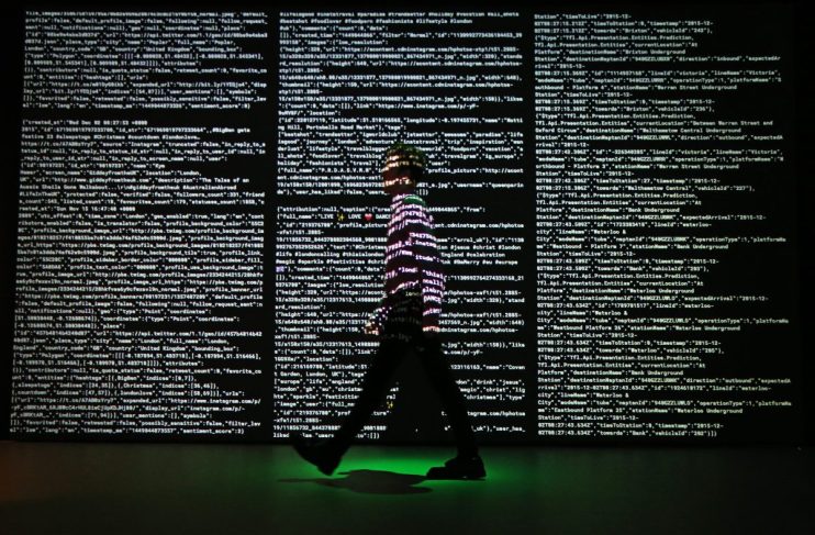 LONDON, ENGLAND - DECEMBER 02: A staff member stands in a projection of live data feeds from (L-R) Twitter, Instagram and Transport for London by data visualisation studio Tekja at the Big Bang Data exhibition at Somerset House on December 2, 2015 in London, England. The show highlights the data explosion that's radically transforming our lives. It opens on December 3, 2015 and runs until February 28, 2016 at Somerset House. (Photo by Peter Macdiarmid/Getty Images for Somerset House)