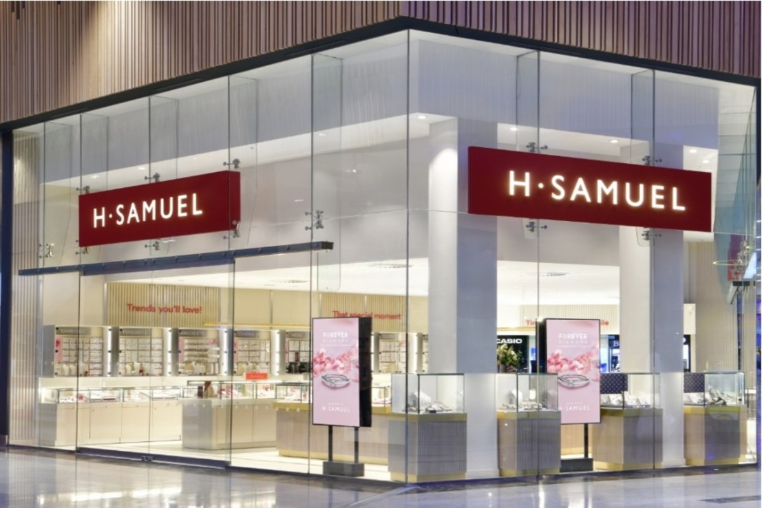 The company behind H Samuel and Ernest Jones has cut its pre-tax loss.