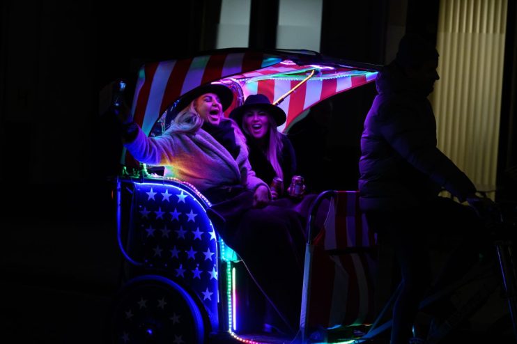 LONDON, UNITED KINGDOM - DECEMBER 06: Two women sing aloud to the onboard stereo system as they're transported through Westminster on a pedicab on December 06, 2023 in London, United Kingdom. (Photo by Leon Neal/Getty Images)