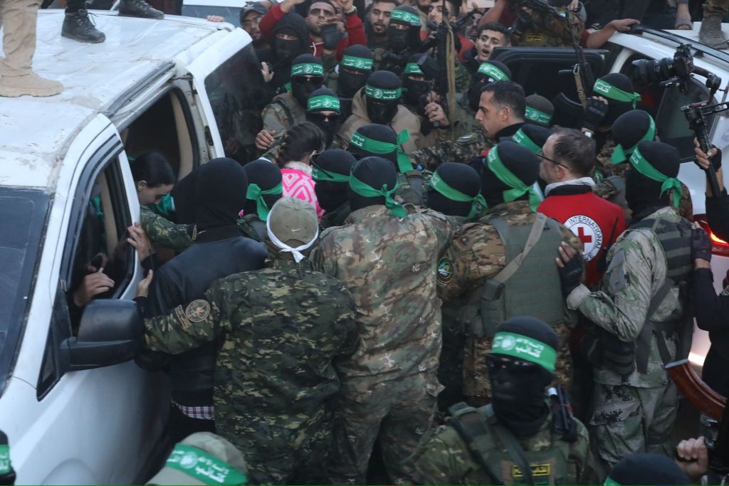 Al-Qassam Brigades hands over 3 Israeli hostages to Red Cross at al-Saraya as part of 1st phase of ceasefire and prisoner swap deal between Israel and Hamas, in Gaza City, Gaza on January 19, 2025. (Photo by Dawoud Abo Alkas/Anadolu via Getty Images)
