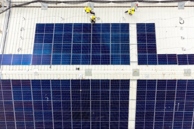 Good Energy workers installing commercial solar panels.