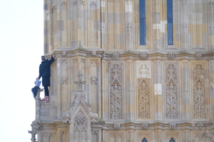 People watch a man with a Palestine flag after he climbed up Elizabeth Tower, which houses Big Ben at the Palace of Westminster in London. Picture date: Saturday March 8, 2025. James Manning/PA Wire Copyright notice: © 2025 PA Media, All Rights Reserved
