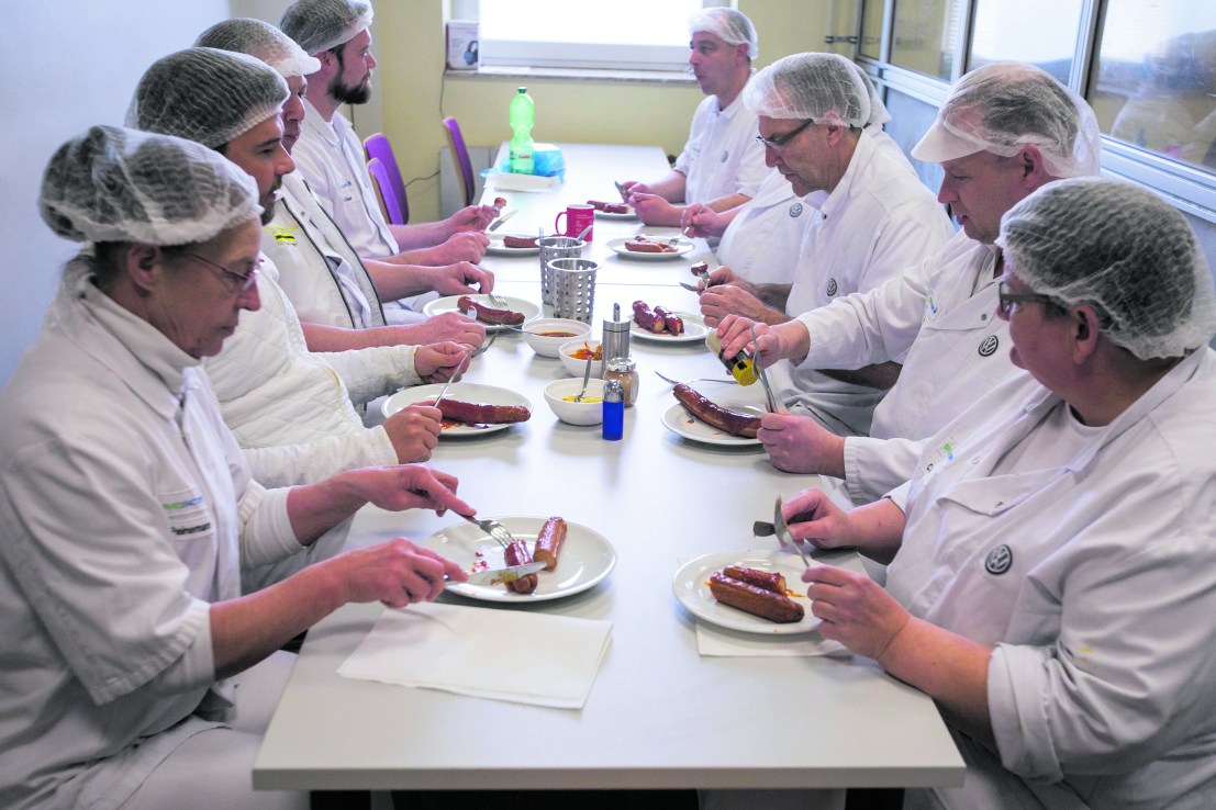 Members of the production team eat currywurst sausages  in the Volkswagen AG manufacturing plant in Wolfsburg, Germany, 2020. (Photographer: Krisztian Bocsi/Bloomberg via Getty Images)