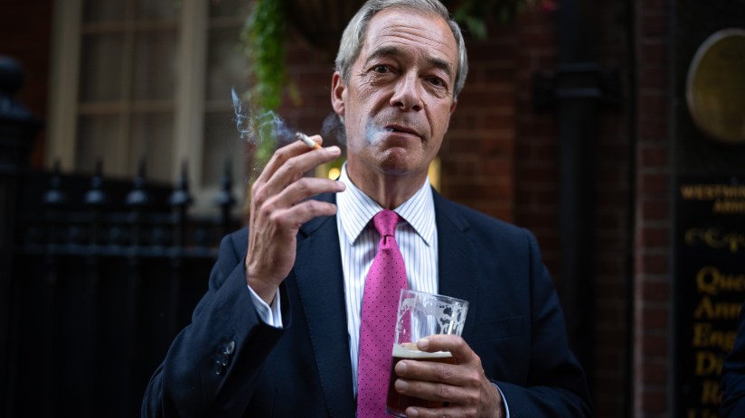 LONDON, ENGLAND - AUGUST 29: Reform UK leader Nigel Farage smokes a cigarette and drinks a pint of ale outside a pub on August 29, 2024 in London, England. The UK government is looking at tougher rules on outdoor smoking to reduce the number of preventable deaths linked to tobacco use. Leader of the Reform UK party, Nigel Farage, said he would never go to a pub again if outside smoking is banned. He accuses the government of ignoring drug abuse, instead implementing policies that will "kill off the traditional pub forever." (Photo by Carl Court/Getty Images)