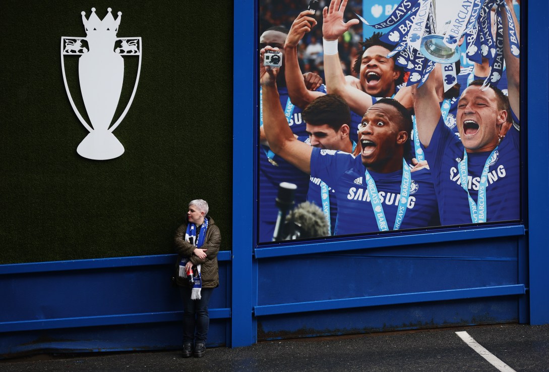 LONDON, ENGLAND - DECEMBER 01: A fan is seen outside the stadium in-front of a picture of former Chelsea players John Terry and Didier Drogba as they lift the 2014/15 Premier League trophy prior to the Premier League match between Chelsea FC and Aston Villa FC at Stamford Bridge on December 01, 2024 in London, England. (Photo by Julian Finney/Getty Images)
