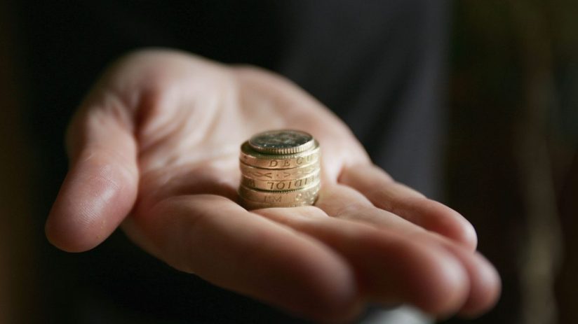 GLASGOW, UNITED KINGDOM - MARCH 11: A hand holding coins on March 11, 2005 in Glasgow, Scotland. As of October 2005 the UK minimum wage will be raised to GBP5.05 from GBP4.85, while 18 to 21 year olds will be paid GBP4.25. An esitmated 1 million people will benefit from the increase. (Photo illustration by Christopher Furlong/Getty Images)